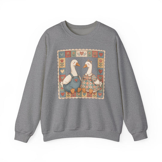 Thrifted Geese Crew: Grey crewneck sweatshirt with folk-art geese illustration, patchwork quilt motif, cozy country-inspired design, made from a comfortable polyester-cotton blend.