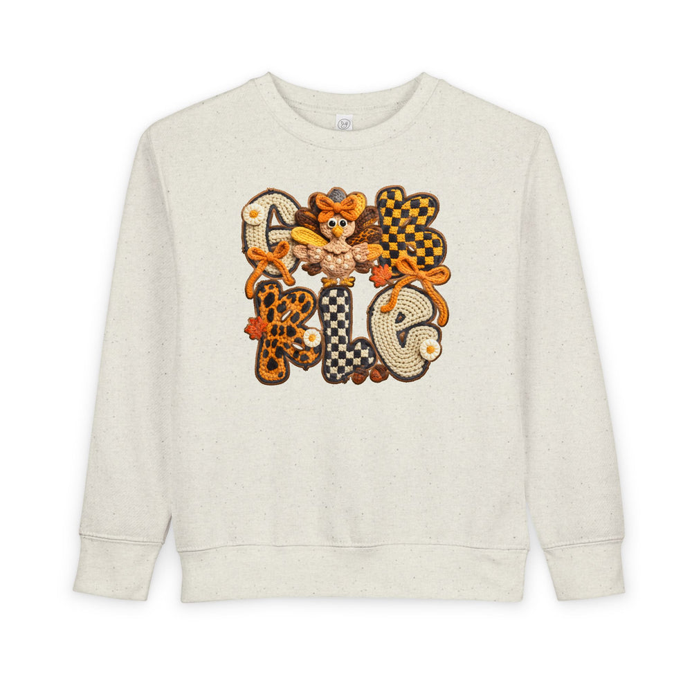 Cream-speckled toddler sweatshirt with GOBBLE in patchwork letters and a cartoon turkey, perfect for cozy, stylish autumn wear from Faith Family Designs.
