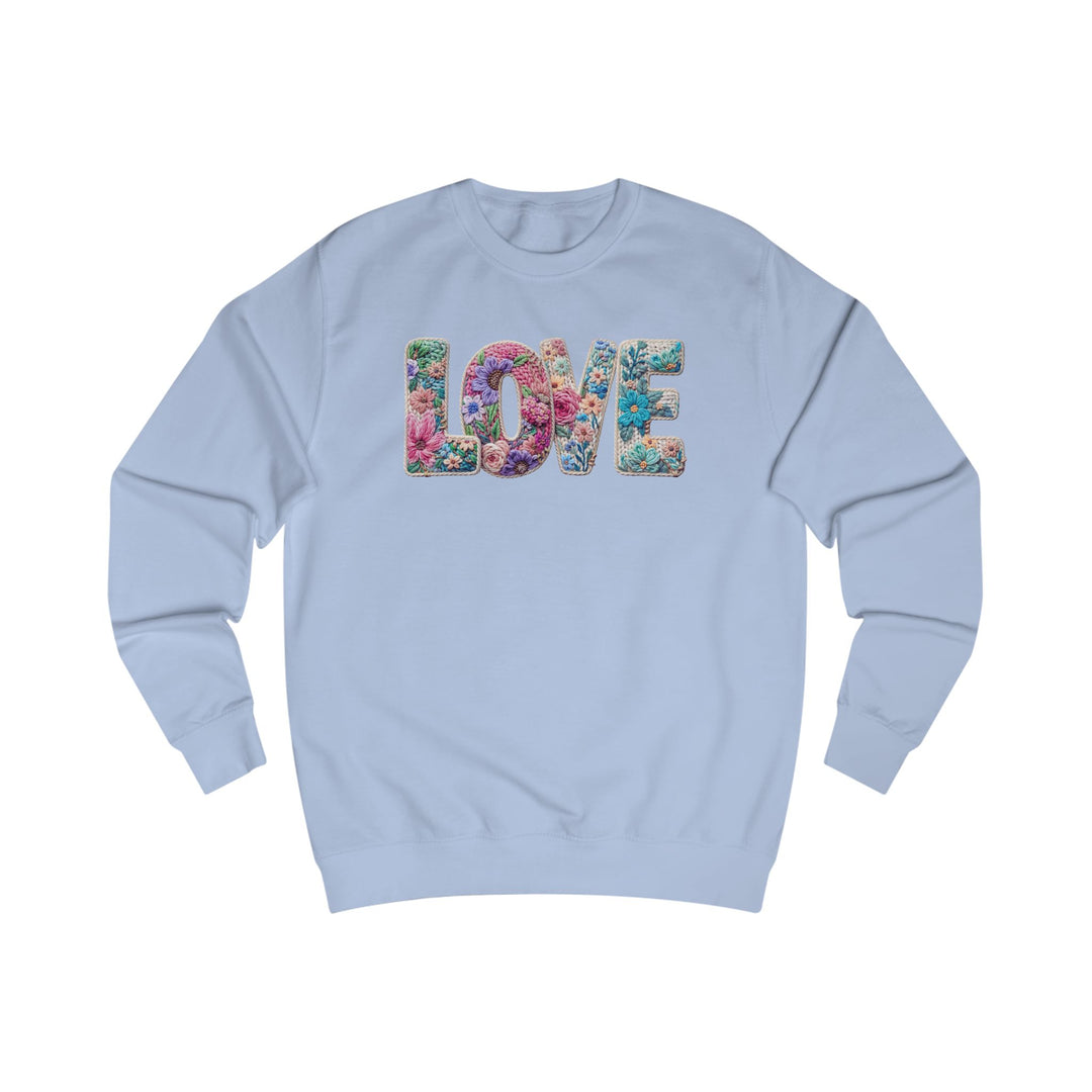 Light blue crewneck sweatshirt with LOVE in floral design on chest, showcasing unique style and comfort from Faith Family Designs.