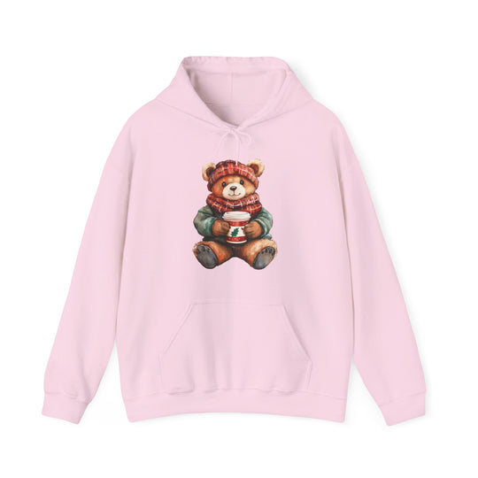Pale pink hoodie featuring a winter-dressed teddy bear illustration, with a kangaroo pocket and matching drawstring, perfect for cozy, stylish wear.