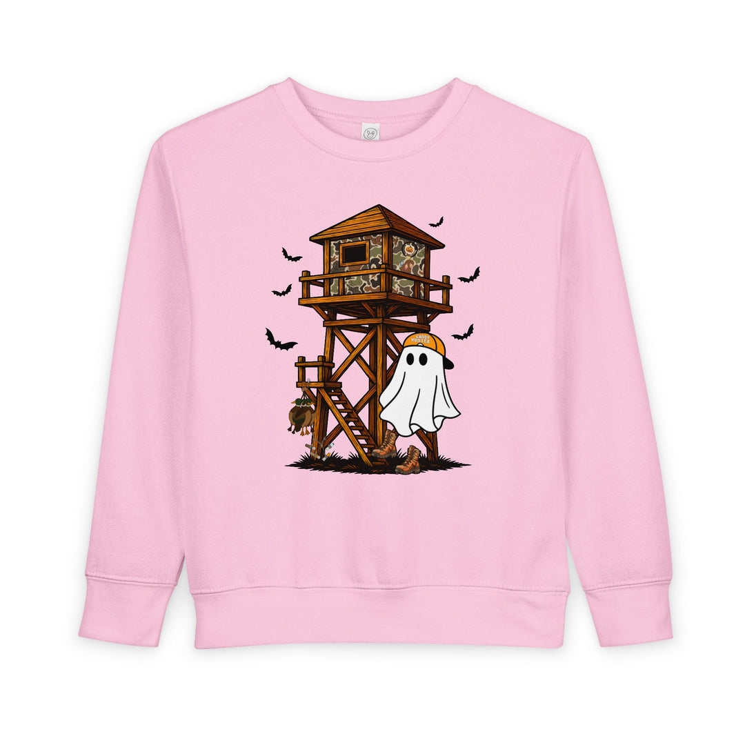 Ghost Hunter Toddler Crew: Light-pink sweatshirt featuring a playful Halloween scene with a ghost in a cap, hunting stand, and flying bats. Cozy, durable fleece blend.