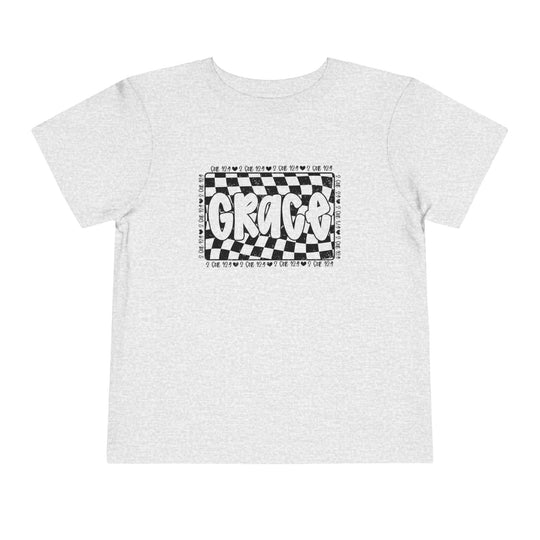 Grace Toddler Tee featuring a black and white checkered design with text, ideal for everyday comfort with its soft, breathable cotton fabric.