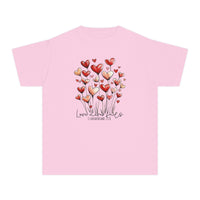Love Never Fails Kids Tee: Light-pink, child-sized shirt featuring heart-shaped bouquet design and inspirational quote, ideal for comfort and activity with soft, durable cotton fabric.