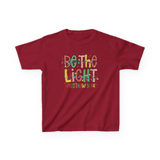 Youth-sized red T-shirt with Be the Light and Matthew 5:14 in festive colors and Christmas lights, perfect for everyday wear.