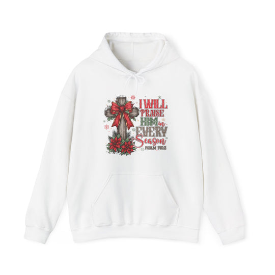 White hoodie with rustic cross and red bow, pine sprigs, poinsettias, snowflakes, and I WILL PRAISE HIM IN EVERY SEASON text. Includes Psalm 149:2 reference.