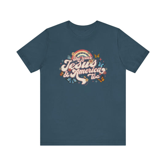 A She Loves Jesus and America Tee featuring a blue t-shirt with a graphic design of butterflies and flowers. Unisex jersey tee with ribbed knit collars, taping on shoulders, and tear away label. Made of 100% Airlume combed and ringspun cotton.