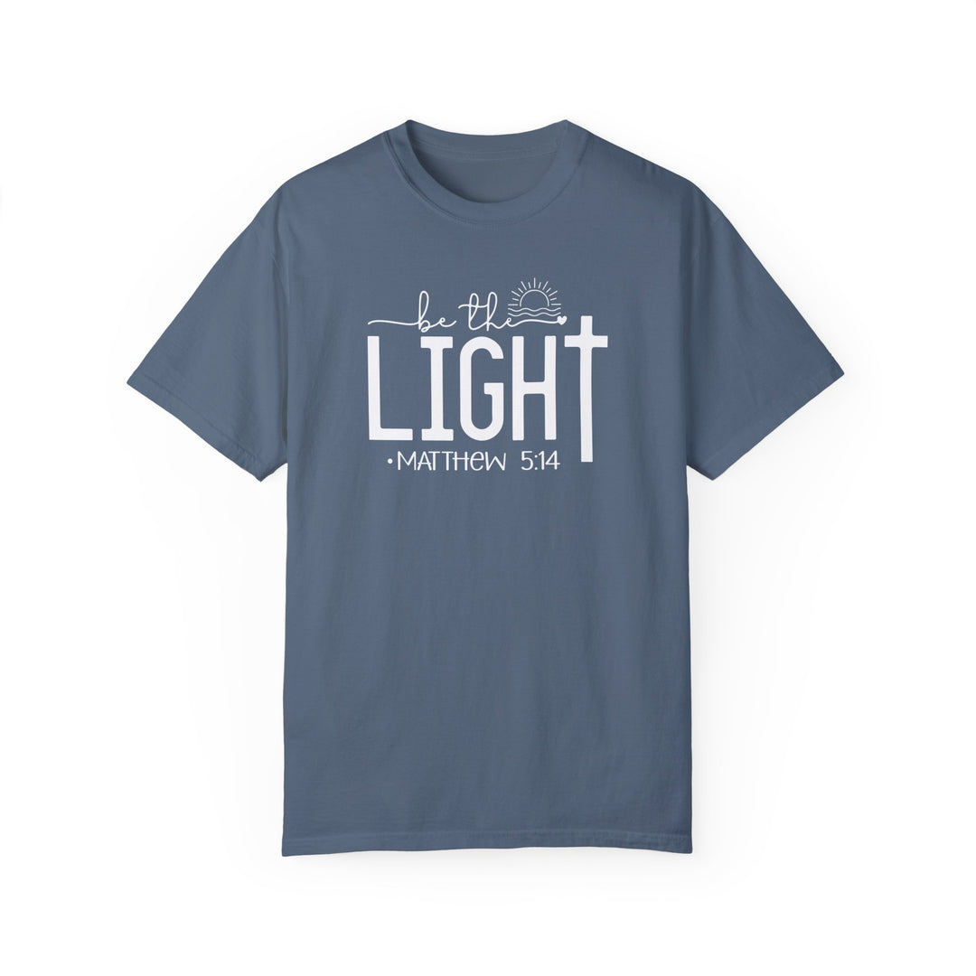 A ring-spun cotton Be the Light Tee, garment-dyed for extra coziness. Relaxed fit, double-needle stitching for durability, and seamless design for a tubular shape. From Worlds Worst Tees.