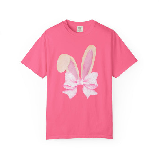 Bright pink T-shirt with watercolor bunny ears and pink bow graphic, labeled Comfort Colors, available in various sizes for a relaxed fit.