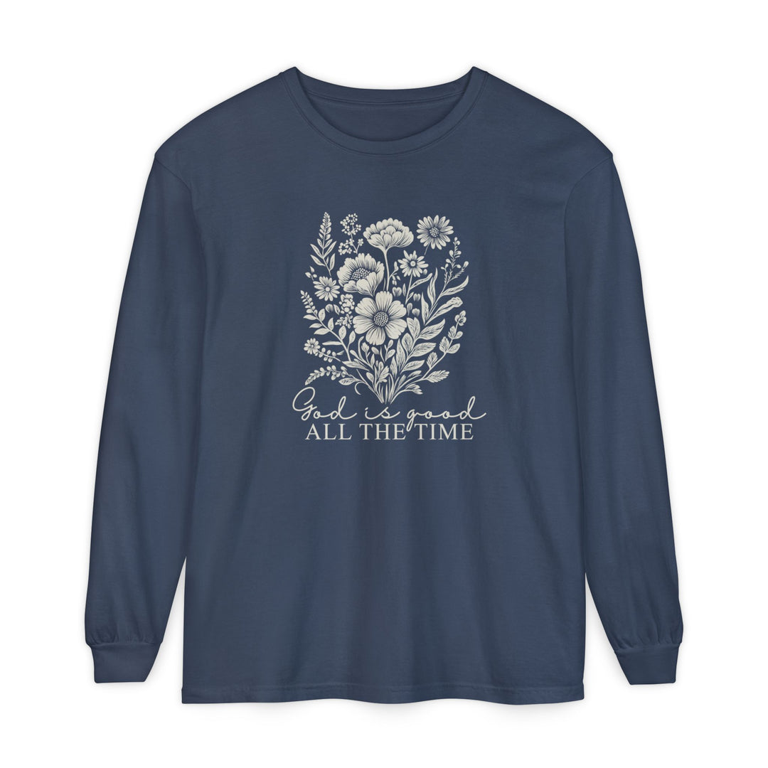 Navy-blue long-sleeve tee featuring a hand-drawn wildflower bouquet and the phrase God is good ALL THE TIME in mixed script and serif fonts.