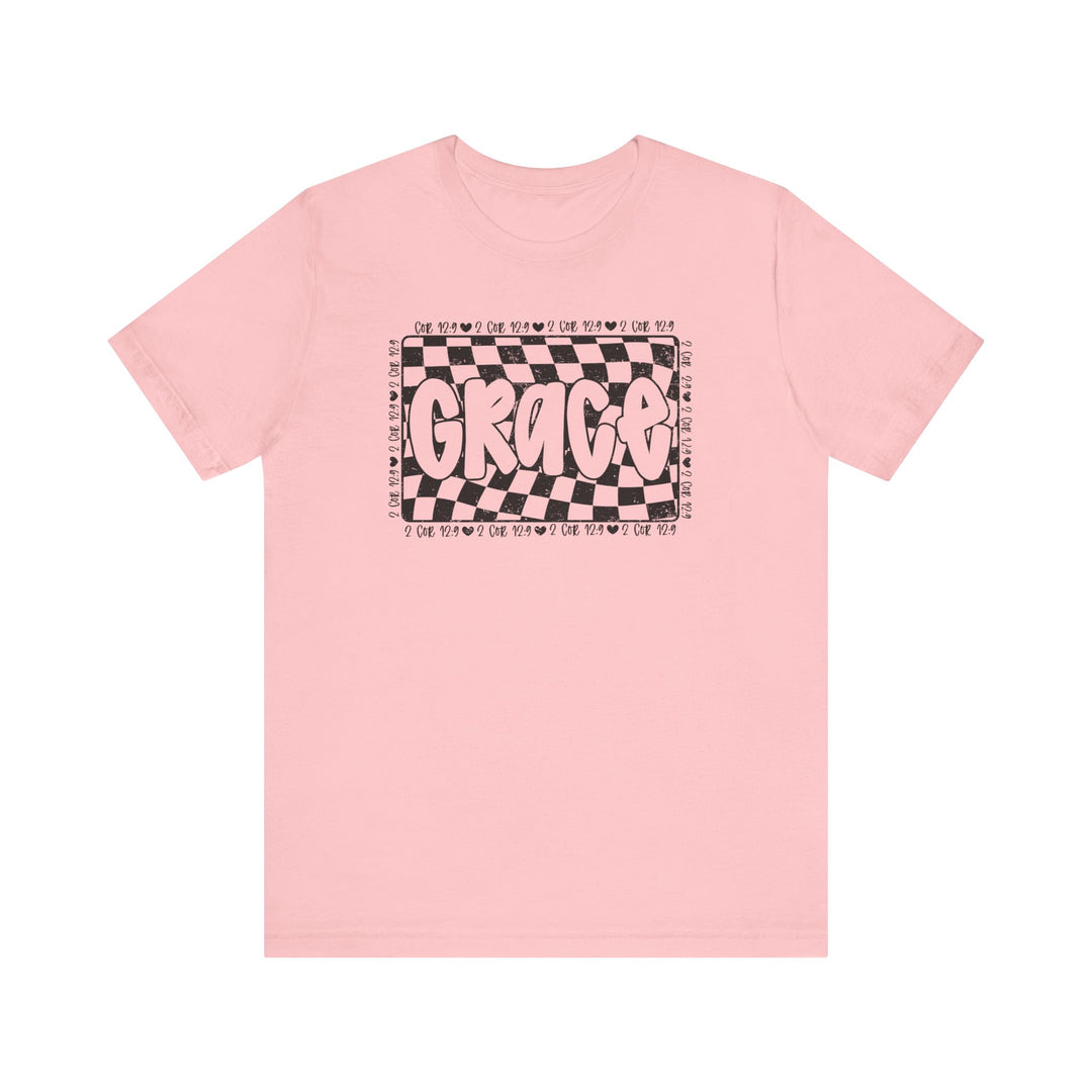 Grace Tee: A pink t-shirt featuring bold black and white text, crafted from soft cotton for a classic unisex fit with ribbed collars and durable seams.