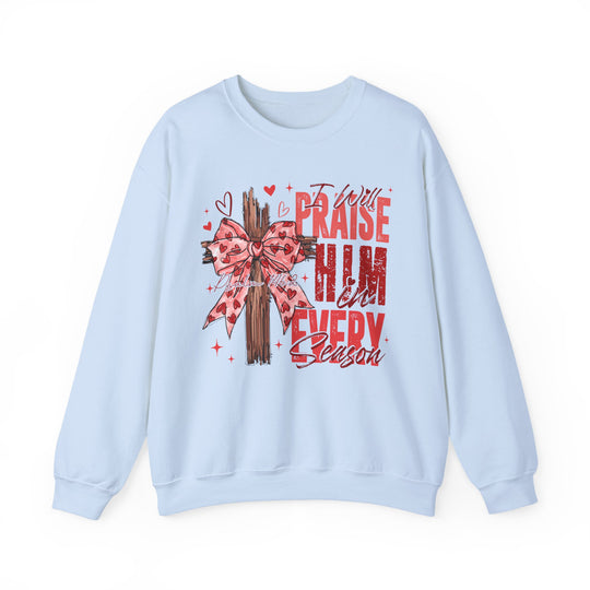 Praise in Every Season Heart Crew sweatshirt features a rustic cross with a heart-patterned bow, surrounded by red text and accents, offering comfort and style.