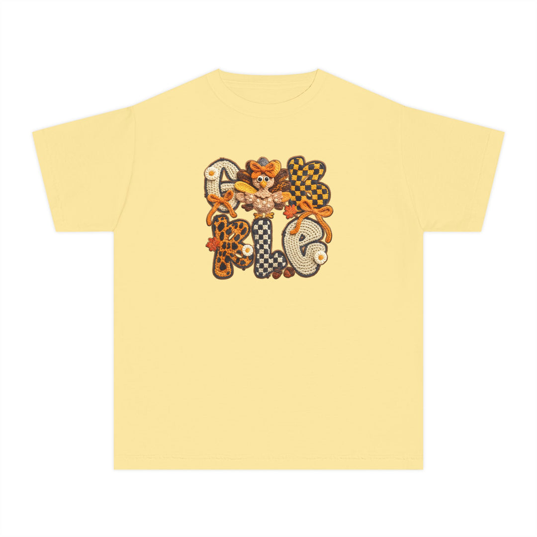 Gobble Kids Tee with fall-themed applique, featuring GOBBLE in various patterns, cartoon turkey, bows, daisies, maple leaves; crafted for comfort with 100% combed cotton.