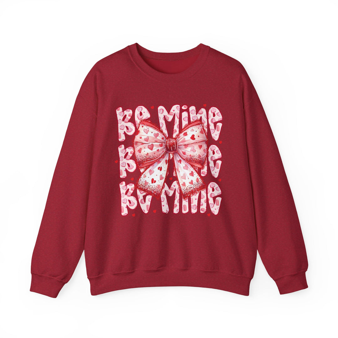 Be Mine Crew: A Valentine's Day-themed sweatshirt featuring a stylized bow and text, offering comfort with a cotton-polyester blend and ribbed knit collar.