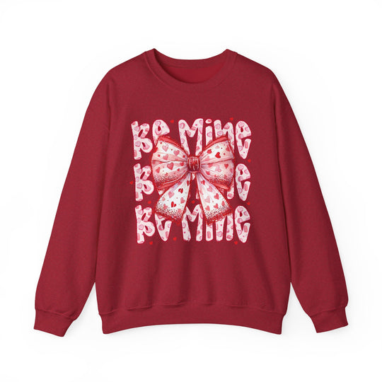 Be Mine Crew: A Valentine's Day-themed sweatshirt featuring a stylized bow and text, offering comfort with a cotton-polyester blend and ribbed knit collar.