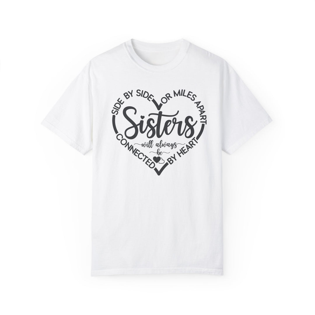 Sisters At Heart Tee: A white t-shirt featuring bold black text, crafted from 100% ring-spun cotton for comfort and durability, ideal for daily wear.