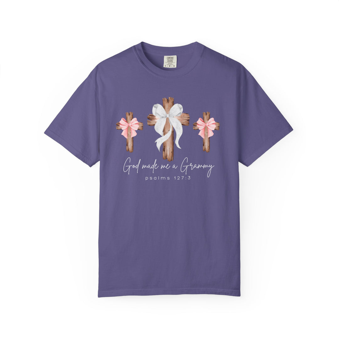 Purple T-shirt with three wooden crosses, center cross larger with white bow, flanked by pink-bowed crosses; text reads “God made me a Grammy,” referencing Psalms 127:3.