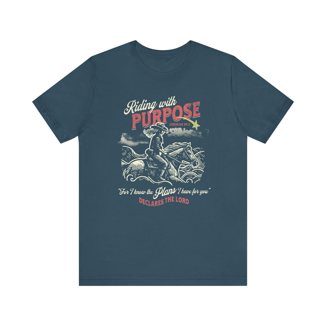 Riding for a Purpose Tee: Blue t-shirt featuring a cowboy riding a horse. Soft cotton, classic fit with ribbed collars, ideal for casual wear.