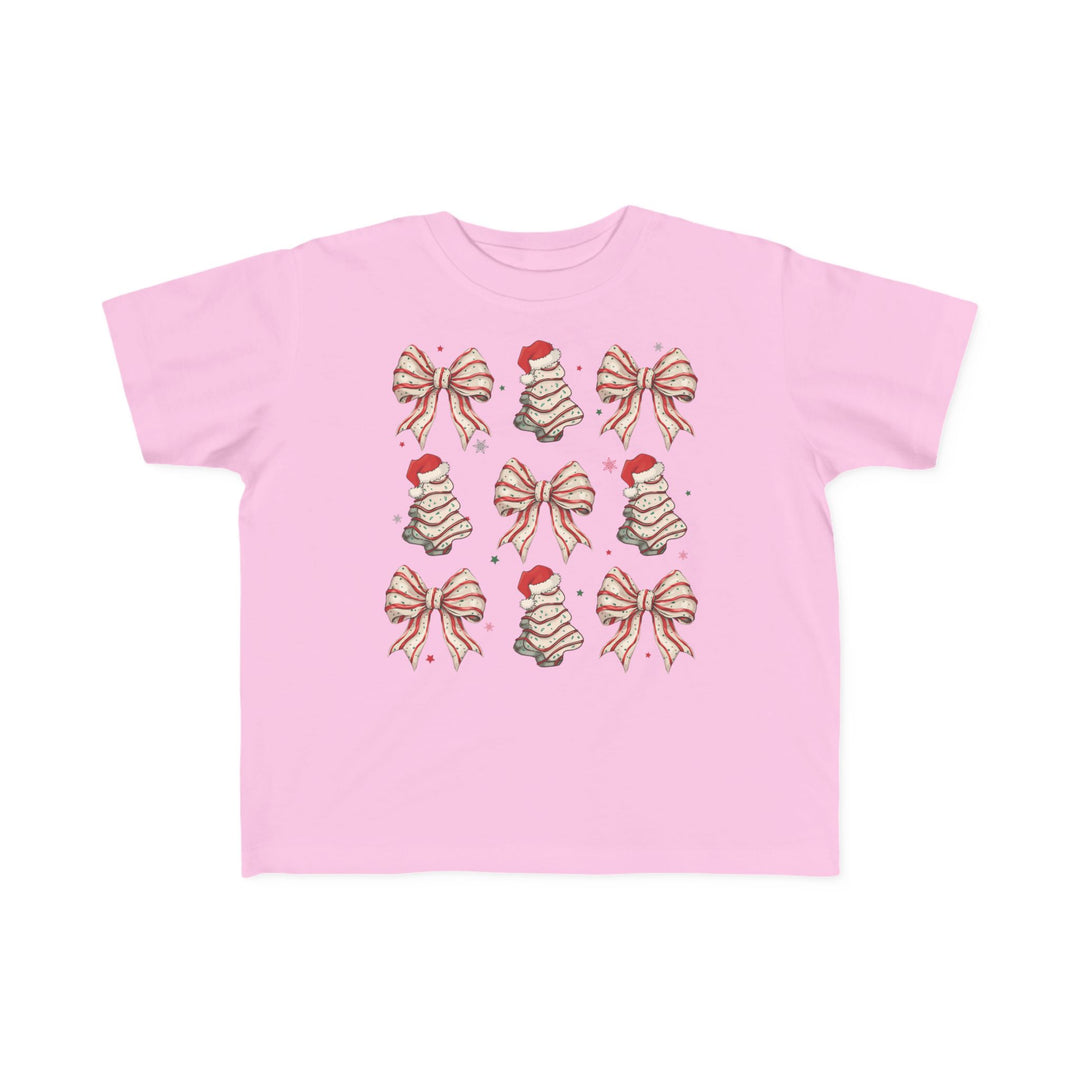 Cookies and Bows Toddler Tee: Light pink T-shirt featuring a 3x3 holiday motif pattern with gift-bows and cake-style Christmas trees, ideal for toddlers' comfort and style.