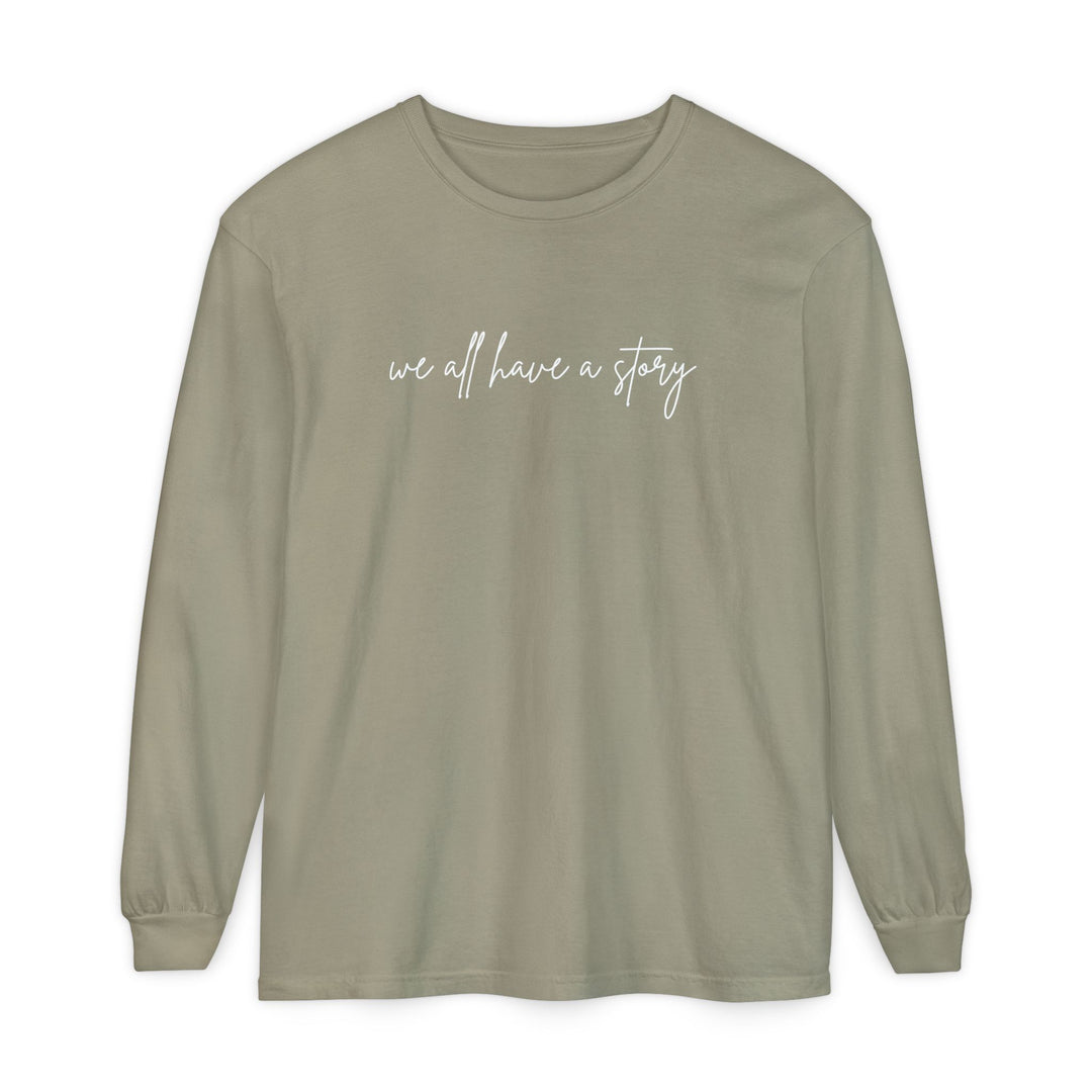 We all have a Story Long Sleeve Tee with white text, featuring a relaxed fit and garment-dyed fabric for comfort and style.