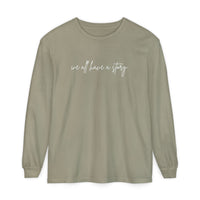 We all have a Story Long Sleeve Tee with white text, featuring a relaxed fit and garment-dyed fabric for comfort and style.