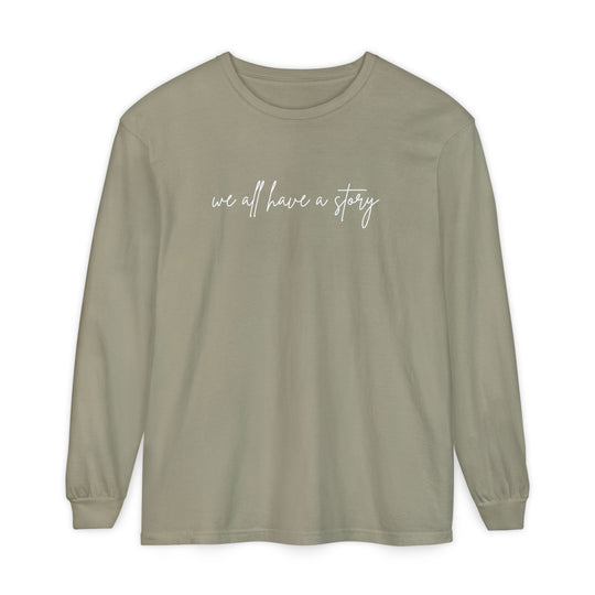We all have a Story Long Sleeve Tee with white text, featuring a relaxed fit and garment-dyed fabric for comfort and style.