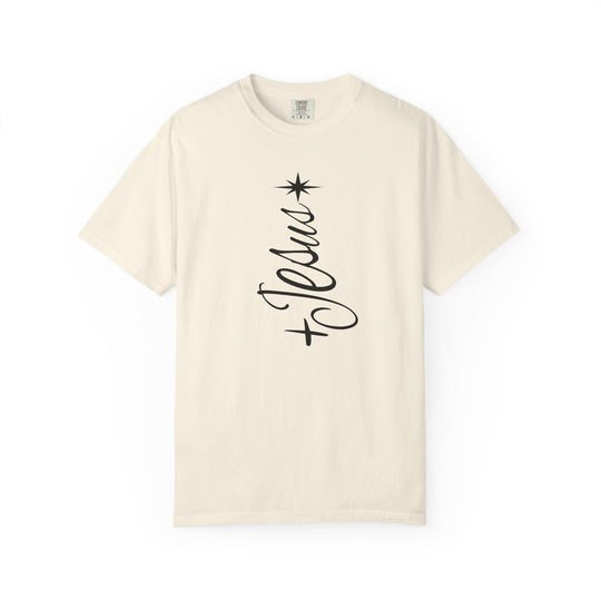 Cream-colored Jesus Tree Tee with a vertical Jesus graphic, resembling a Christmas tree with an eight-pointed star on top. Short sleeves, minimalist design.