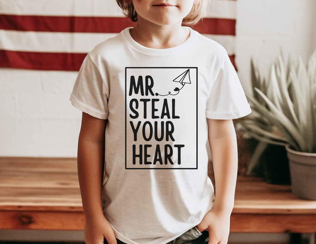 Mr. Steal Your Heart Toddler Tee featuring a bold hand-lettered design with a paper-airplane graphic, perfect for sensitive skin and adventurous toddlers.