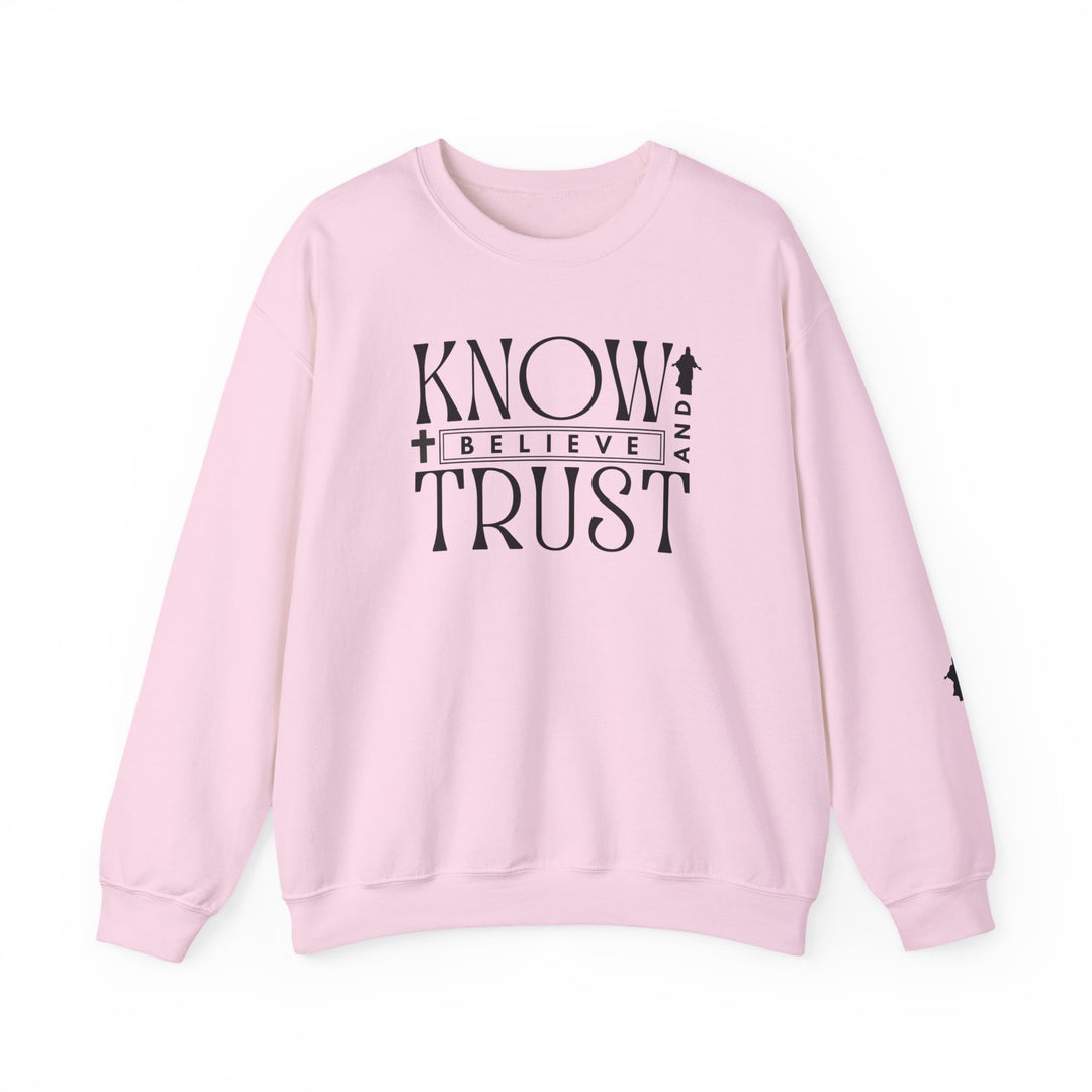 Pink crewneck sweatshirt with black text, Trust, Know, Believe, featuring a casual design perfect for cooler months with durable stitching and a comfortable fit.