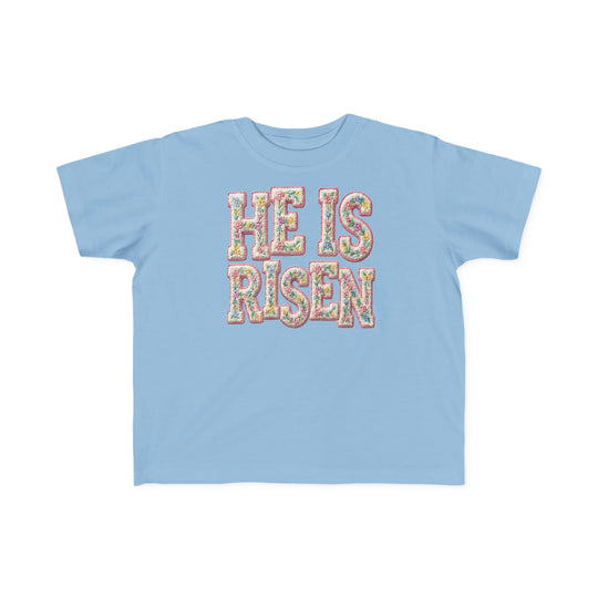 He is Risen Toddler Tee: Light-blue, short-sleeve shirt featuring HE IS RISEN in pastel floral pattern, crafted for toddlers with soft, durable cotton; perfect for sensitive skin.