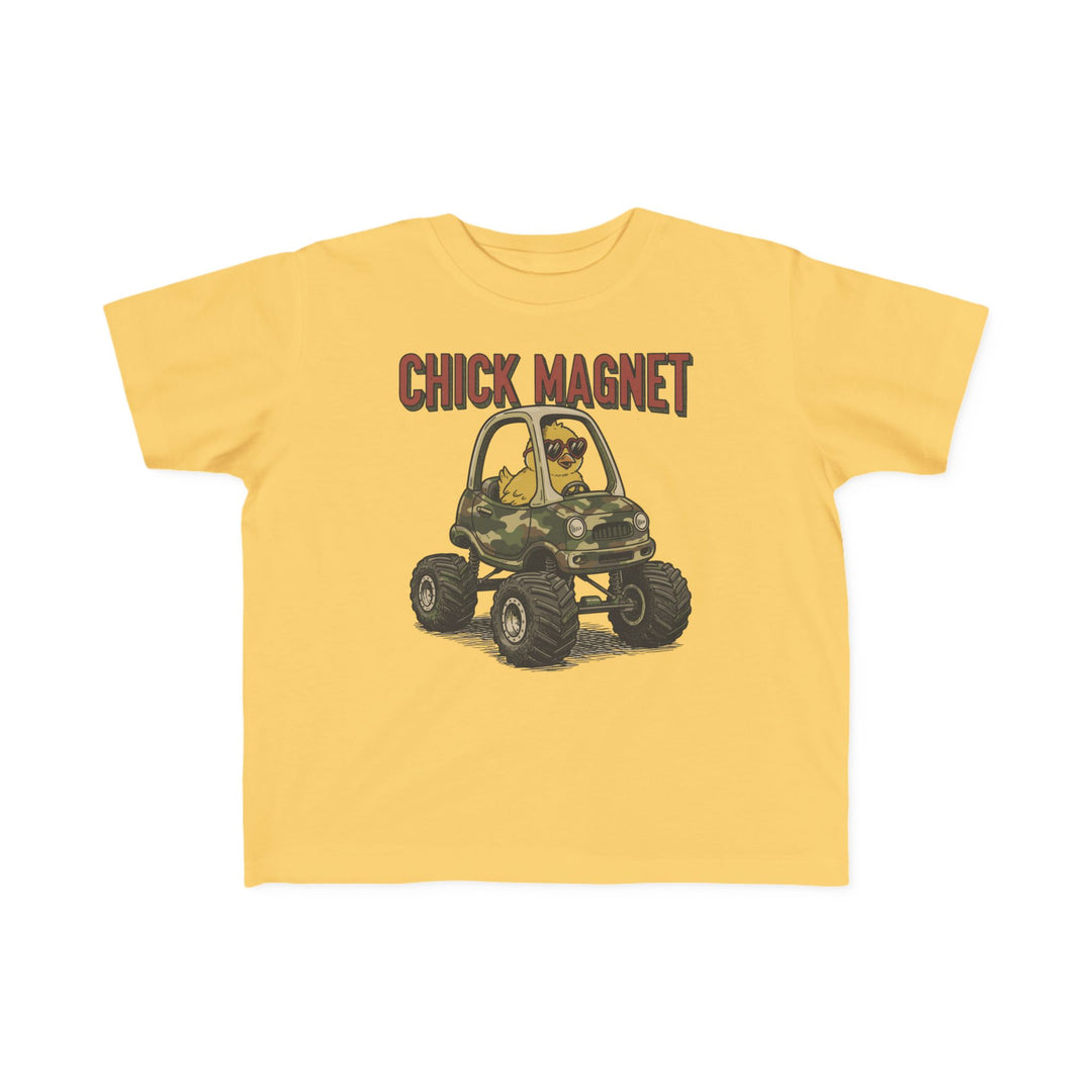 Chick Magnet Toddler Tee features a cartoon chick in sunglasses driving a camo monster truck, with caption CHICK MAGNET. Soft, durable cotton perfect for toddlers.