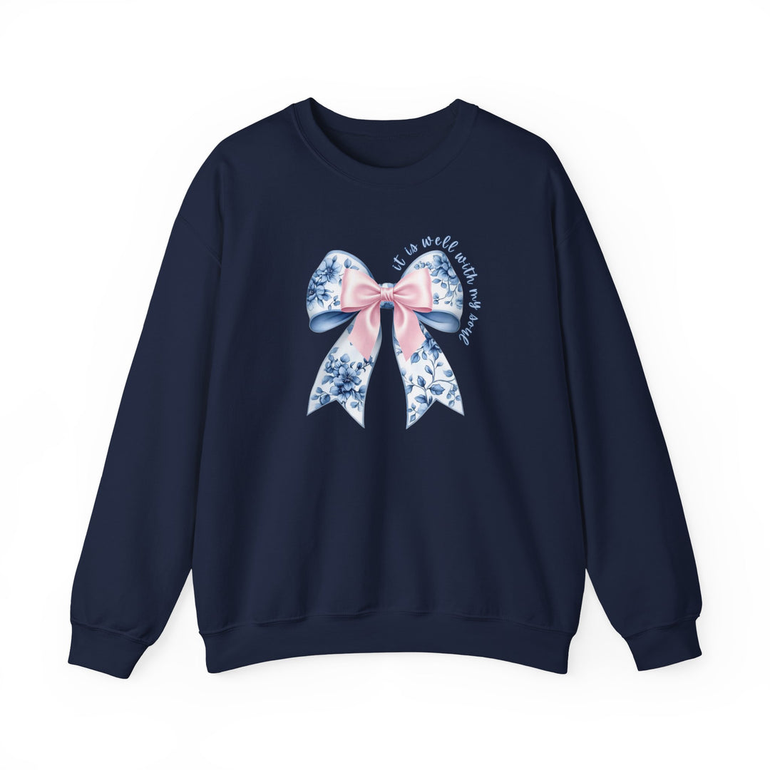 Navy-blue crewneck sweatshirt featuring a decorative bow with floral pattern and It is well with my soul script, combining comfort and style.