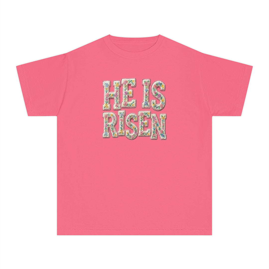 He is Risen Kids Tee featuring floral-patterned text on a pink T-shirt, designed for comfort and agility with 100% combed ring-spun cotton.