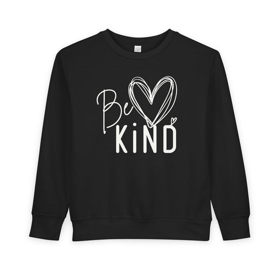 Black toddler crew-neck sweatshirt with Be Kind white graphic, featuring a heart-shaped o. Made from soft, durable cotton-polyester blend for comfort and warmth.