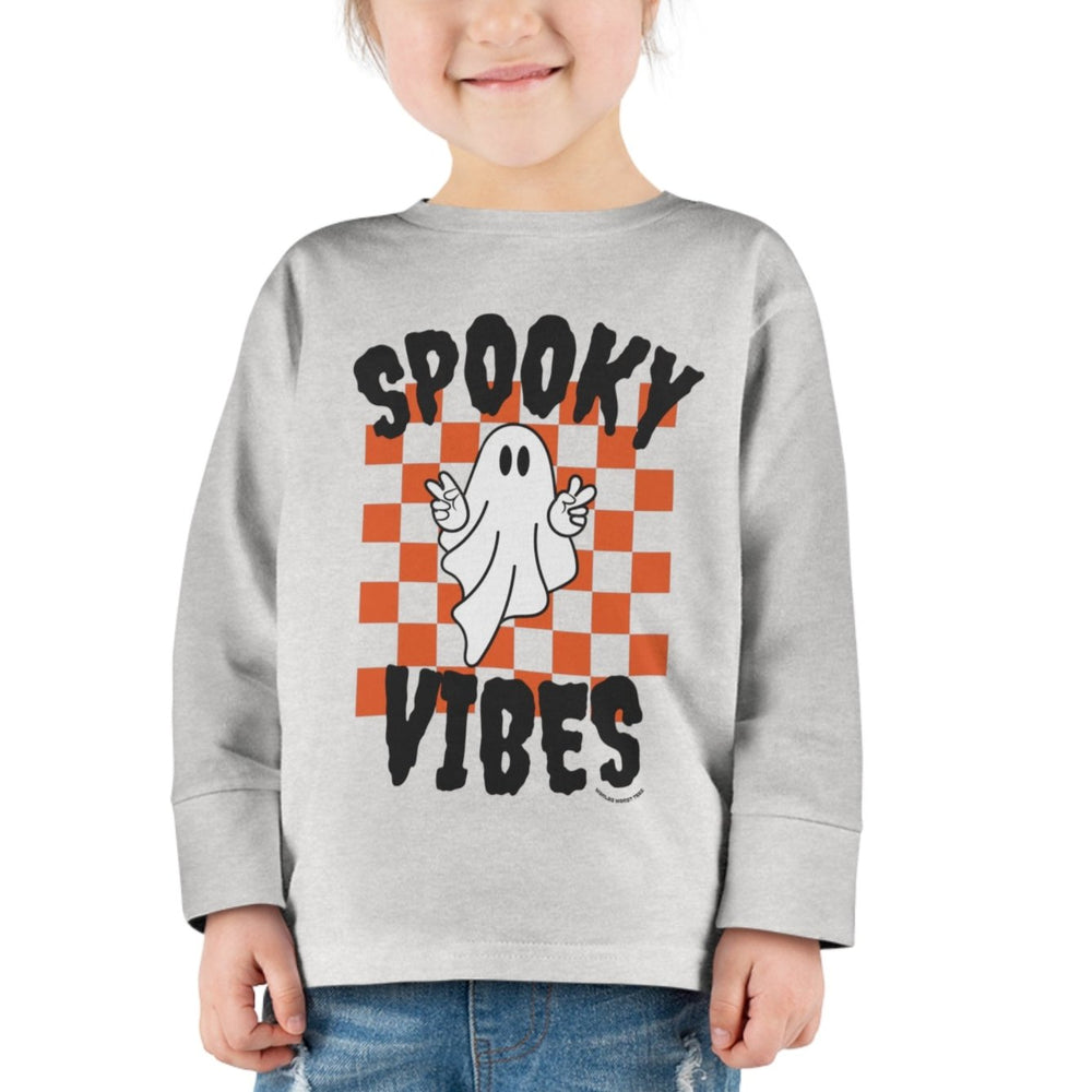 A spooky vibes toddler long sleeve tee featuring a ghost design on a white shirt. Made of 100% combed ringspun cotton, with topstitched ribbed collar and EasyTear™ label for comfort and durability.