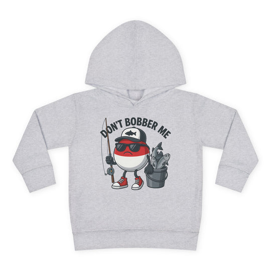 Don't Bobber Me Toddler Hoodie features a cartoon fishing bobber with sunglasses and fishing gear, emphasizing playful design and comfort for kids.