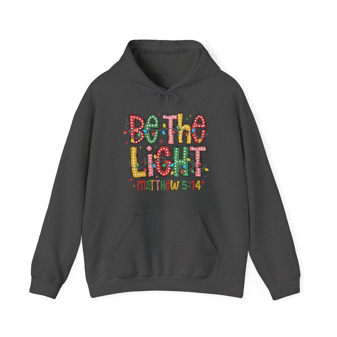 Be the Light Hoodie featuring a colorful hand-lettered graphic with festive lights on a charcoal pullover, complete with a kangaroo pocket and drawstring hood.