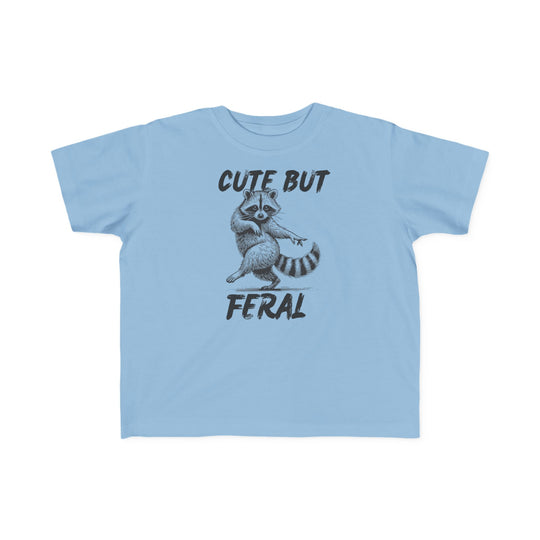 Cute but Feral Toddler Tee: Light-blue T-shirt with hand-drawn raccoon and bold “CUTE BUT FERAL” text, perfect for toddlers' sensitive skin.