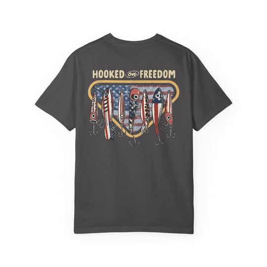Hooked on Freedom Tee features a patriotic fishing graphic on the back, showcasing red, white, and blue lures over an American flag backdrop.