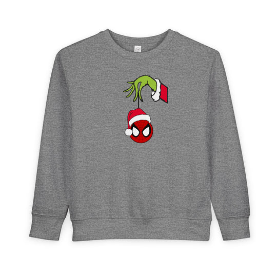 Spider Ball Christmas Toddler Crew sweatshirt featuring Grinch holding Spider-Man mask ornament, offering cozy comfort with its soft cotton-poly blend.