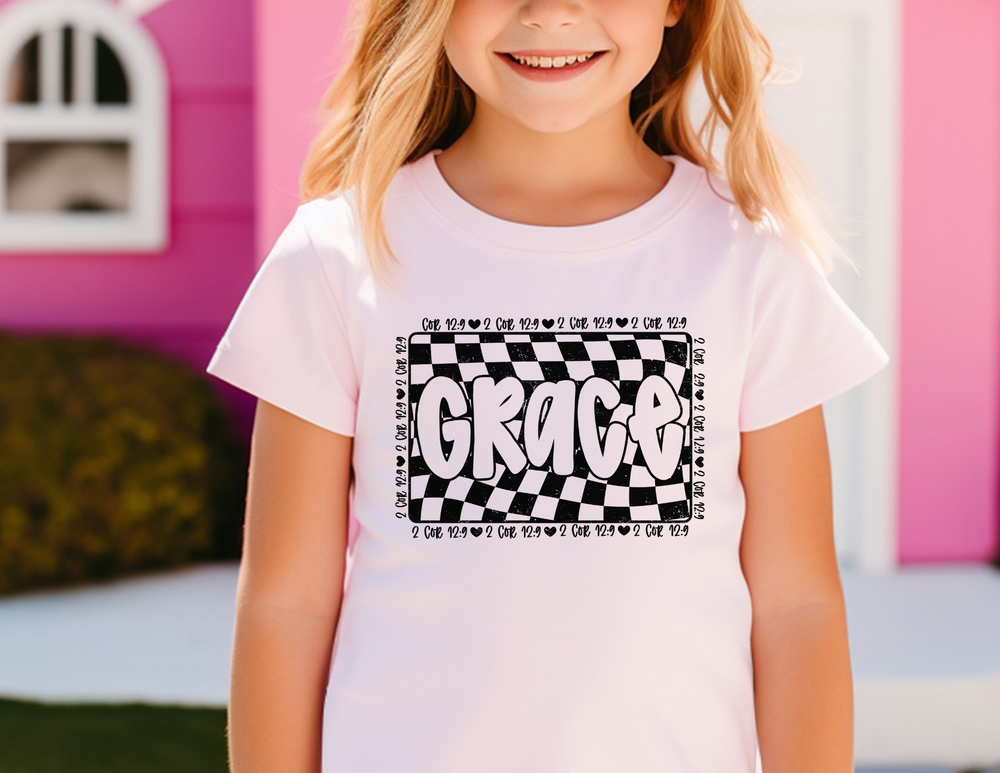 Toddler wearing the Grace Toddler Tee, smiling. The Bella Canvas short sleeve t-shirt offers comfort with its 100% Airlume combed cotton and tear-away label.