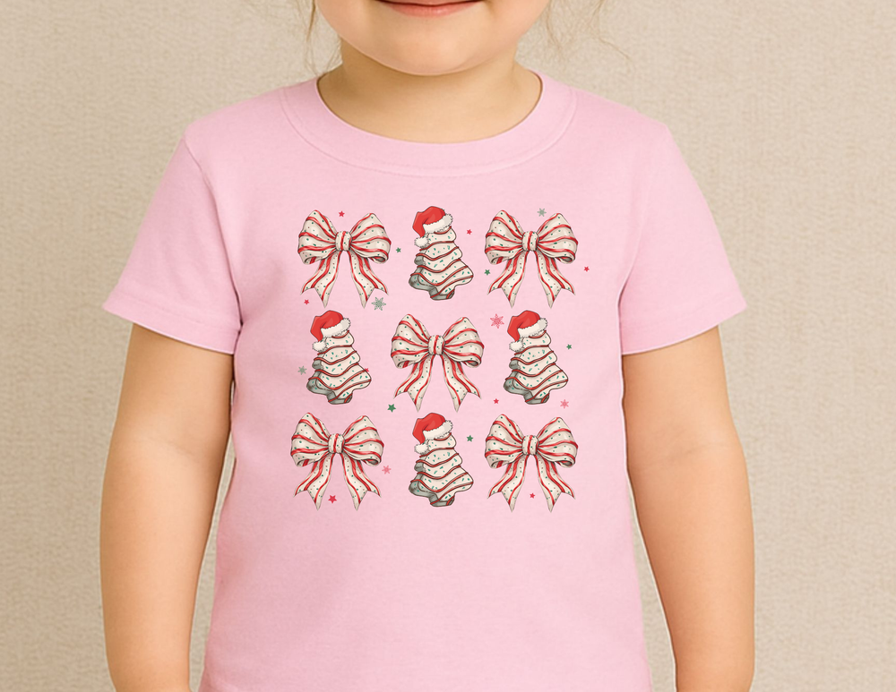 Cookies and Bows Baby Tee: Light pink T-shirt featuring a festive pattern of candy-striped bows and Santa-topped fir-trees, perfect for stylish, comfortable baby wear.
