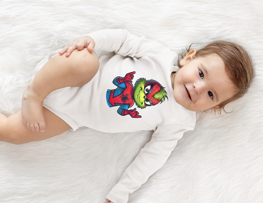 Baby in a Christmas Spider Onesie featuring the Grinch in a Spider-Man suit, lying on a soft surface, highlighting playful and unique design.
