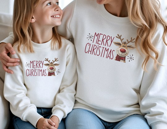 Adult and child wearing matching Merry Christmas reindeer sweatshirts, showcasing festive design and cozy comfort for toddlers from Faith Family Designs.