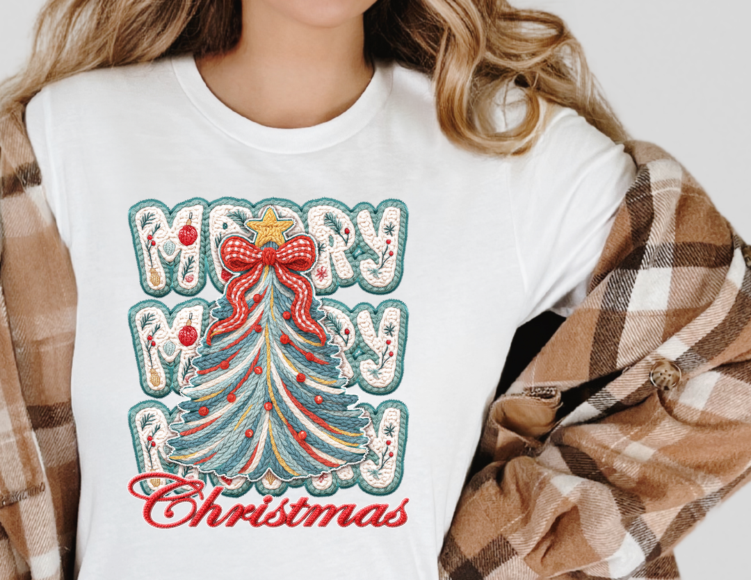 Person wearing Merry Christmas Tree Tee with festive embroidered-style graphic, featuring a yarn-like Christmas tree and MERRY MERRY Christmas text, under a plaid shacket.