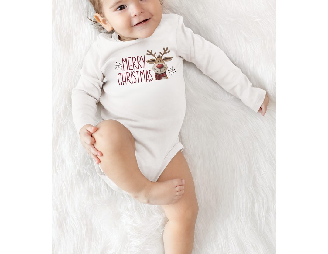 Baby wearing Merry Christmas Reindeer Onesie on fluffy surface, showcasing a festive design. The onesie is soft, with plastic snaps for easy changing.
