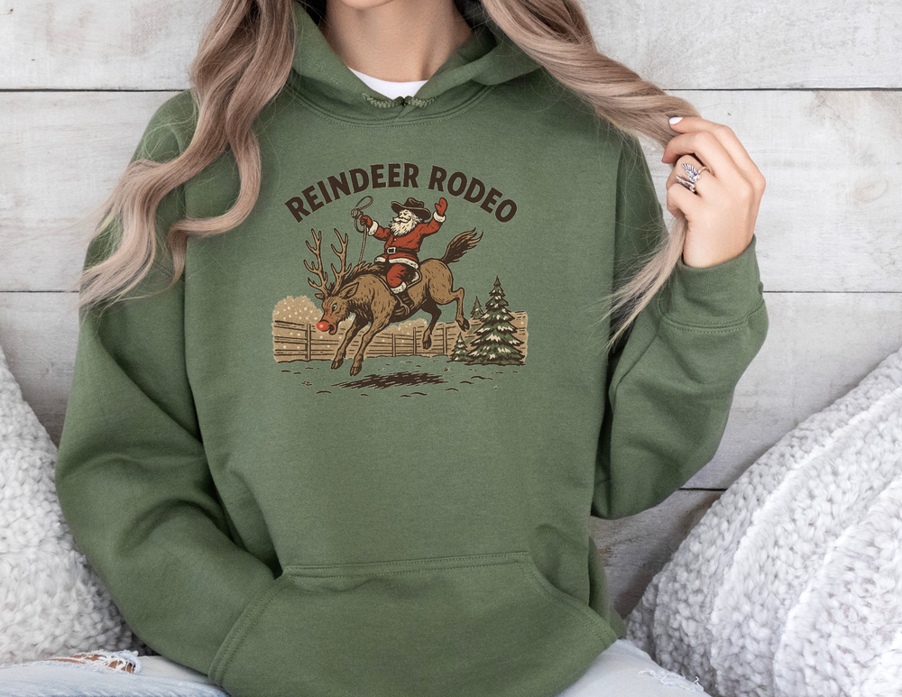Person wearing the Reindeer Rodeo Hoodie featuring Santa as a cowboy on a reindeer, capturing a fun holiday-western theme with cozy, warm design details.