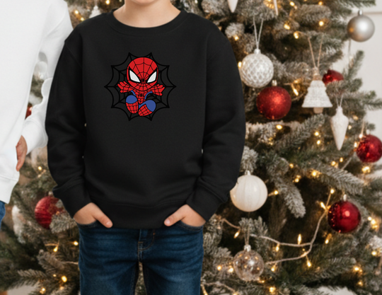Child wearing Spider Kid Toddler Crew sweatshirt with Spider-Man design stands before decorated Christmas tree, displaying cozy, durable fabric ideal for toddlers.