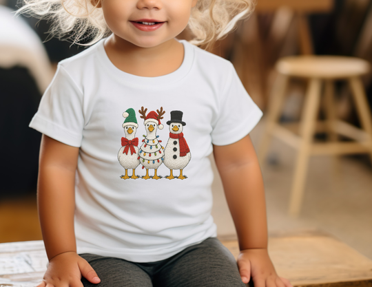 Toddler wearing Christmas Geese Toddler Tee featuring festive birds dressed as Santa, reindeer, and snowman; perfect for sensitive skin with durable print.