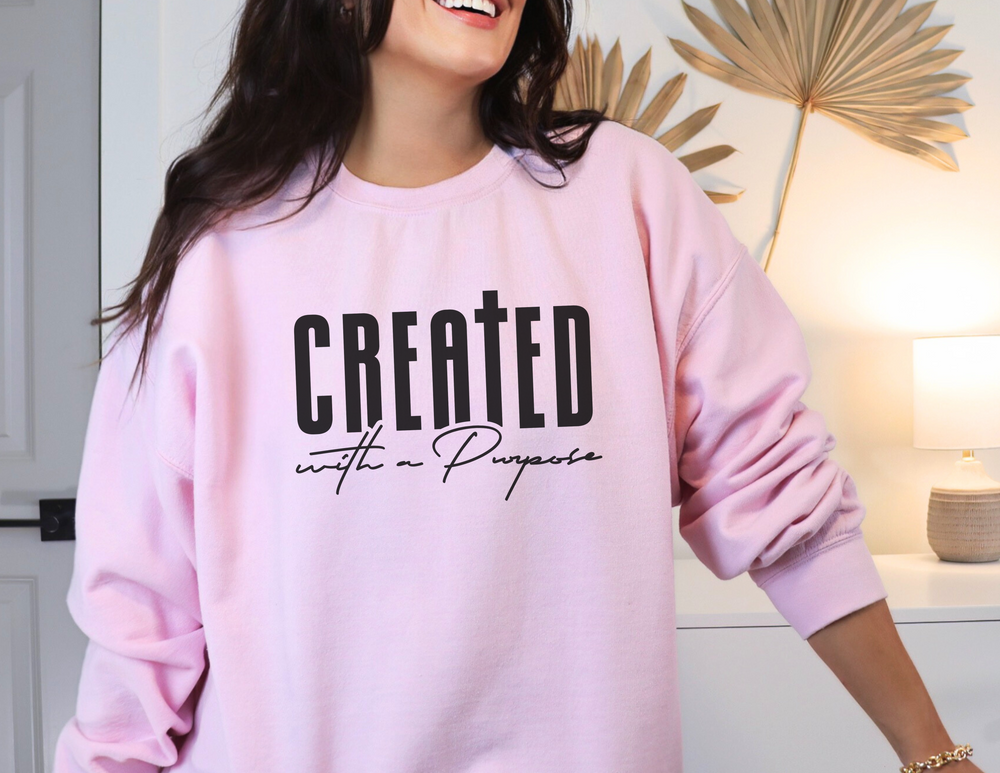 A unisex heavy blend crewneck sweatshirt, the Created With A Purpose Crewneck, offers comfort with a ribbed knit collar, no itchy side seams, and a loose fit. Made of 50% cotton and 50% polyester.