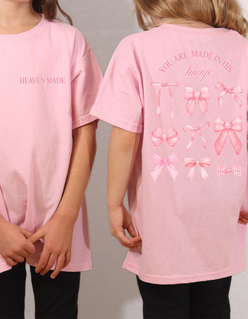 Two children in pastel-pink Heaven Sent Toddler T-shirt, featuring HEAVEN MADE front text and back print with bows and inspirational message.